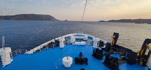 Fotografi Bow of a large passenger ship sailing through a narrow strait between islands, capturing the beauty and precision of maritime navigation
