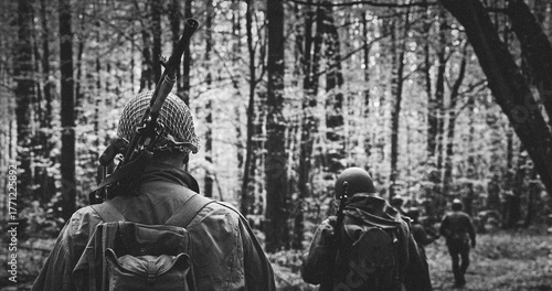 Black and White Image of Soldiers Walking on a Woodland Path