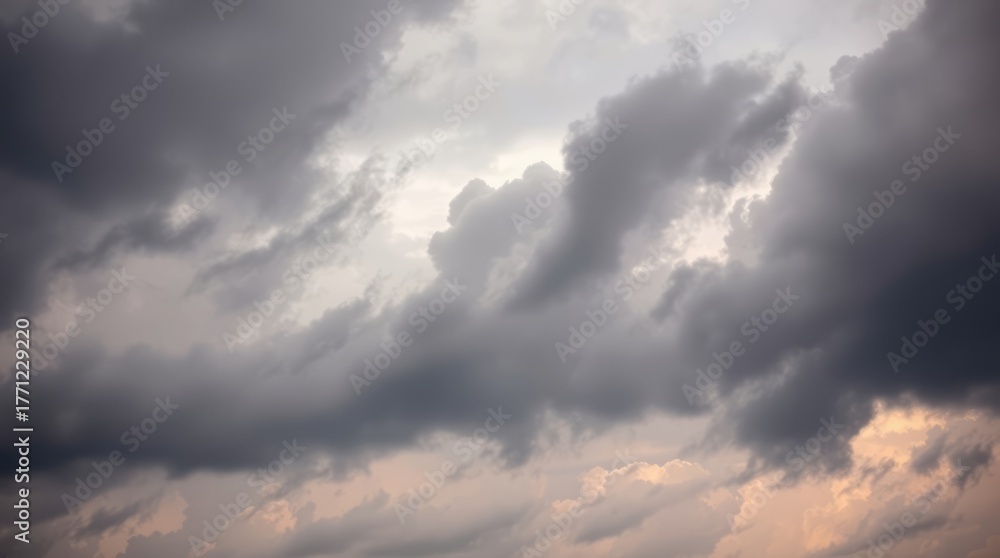 Fototapeta premium Cloudscape's Dramatic Veil: Capturing the essence of a turbulent sky, heavy clouds form a captivating tapestry. The interplay of light and shadow, creating a dynamic visual experience