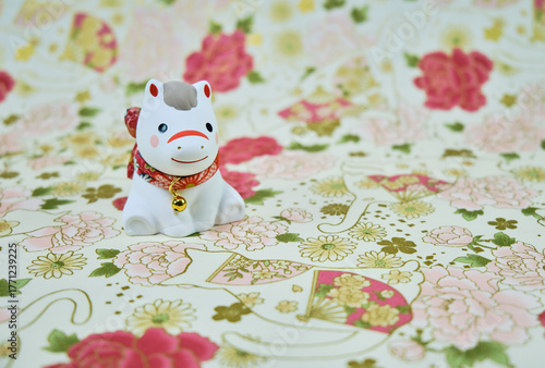 可愛い馬の置物と和柄の背景の年賀状素材