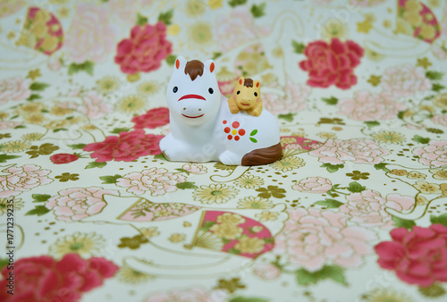 可愛い馬の置物と和柄の背景の年賀状素材