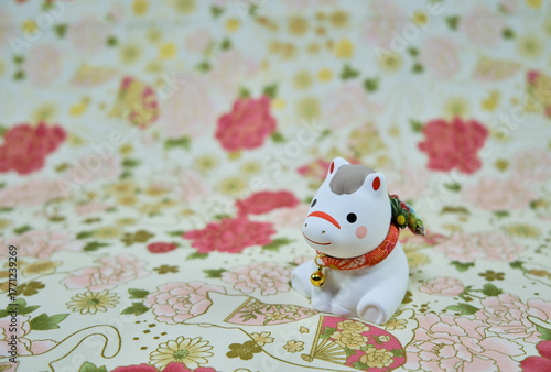 可愛い馬の置物と和柄の背景の年賀状素材