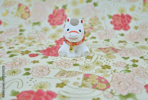 可愛い馬の置物と和柄の背景の年賀状素材