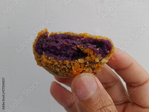Asian man is holding purple sweet potato ball food