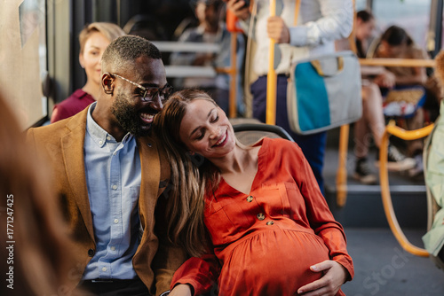 Pregnant couple traveling on bus, embracing love and happiness