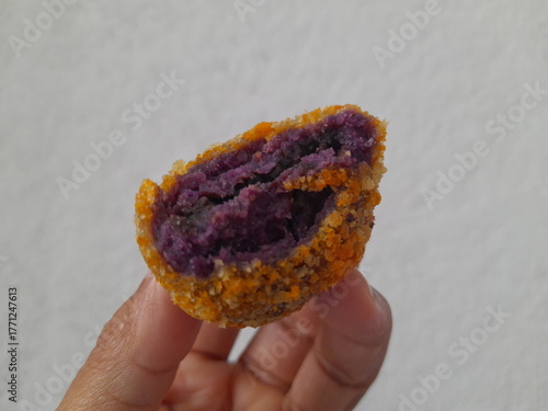 Asian man is holding purple sweet potato ball food