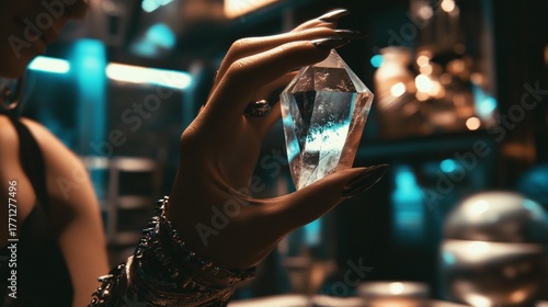Mysterious hand adorned with a bracelet holding a luminous clear crystal in a dark, intriguing