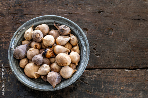 Black garlic, aged garlic in the wood bowl. 