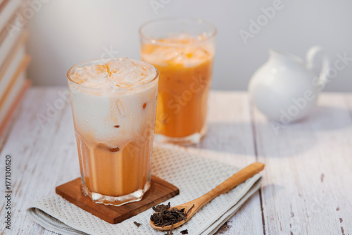 Thai tea with milk in a glass jar placed on a wooden table