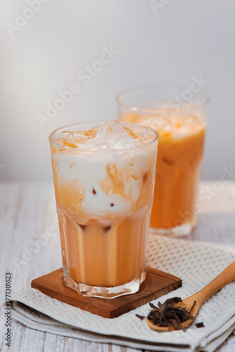 Thai tea with milk in a glass jar placed on a wooden table