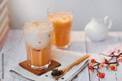 Thai tea with milk in a glass jar placed on a wooden table