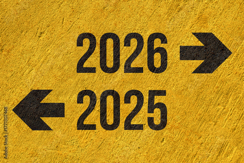 2025 to left 2026 to right painted on yellow concrete wall, new year new way business concept, the past and the future, results and forecasting