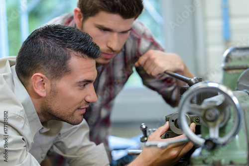 Fotografie mentor and young manual worker in industry