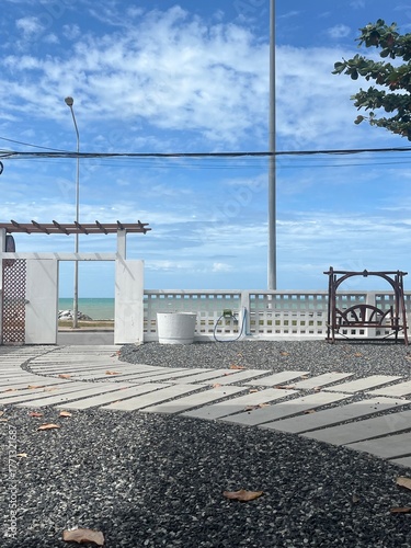 Scenic coastal path leading to the ocean on a sunny day
