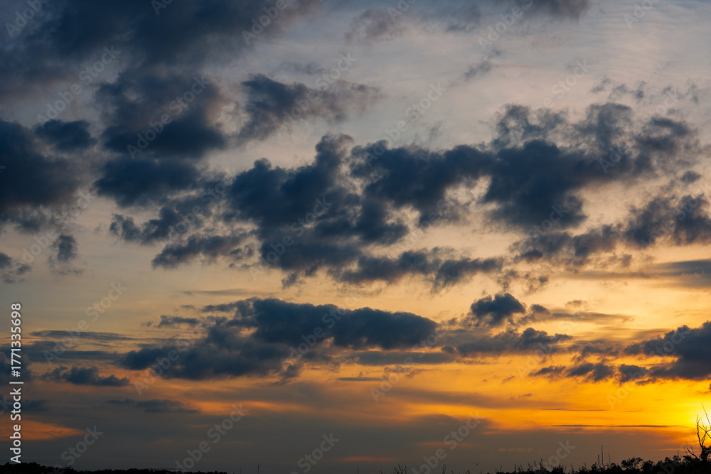 Fototapeta premium Sunset sky clouds in the Evening with Golden orange sunlight in golden hour, Dusk sky background
