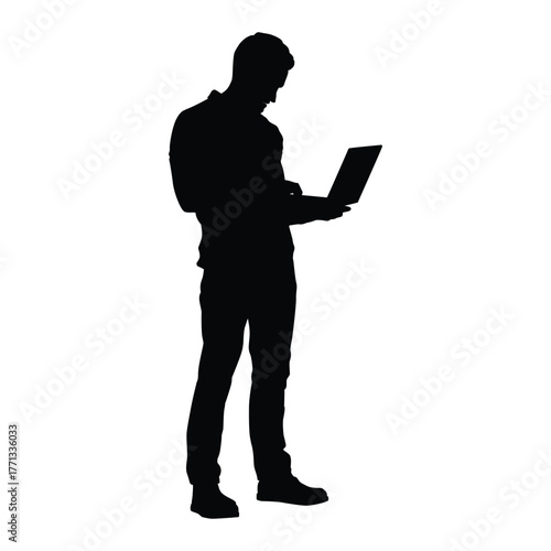 Silhouette of a focused man standing and actively using a laptop computer. Represents remote work, business, technology, programming, and connectivity.