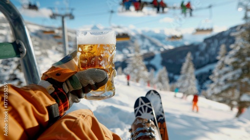 A person wearing ski gloves is holding a frosty glass mug of beer while sitting on a ski lift chair