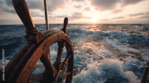 Wooden ship wheel on a boat sailing at sunset over the ocean