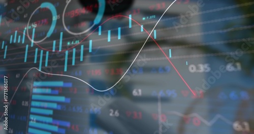Displaying translucent candlestick and line graphs over wooden desk, with smartphone and laptop pen