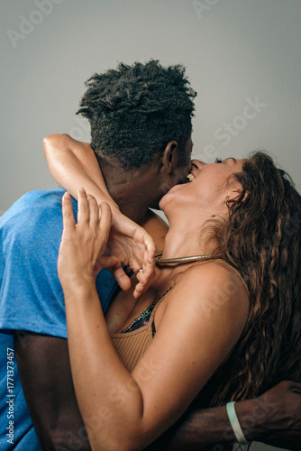 Happy couple sharing a joyful kiss in a cozy indoor setting during a sunny afternoon