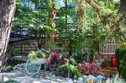 a composition with a bicycle, flowers, and birdhouses on a tree for decoration at the cable car in Pyatigorsk, Russia