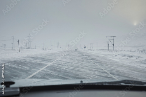 Fotografie Winter road with a snowstorm and strong winds