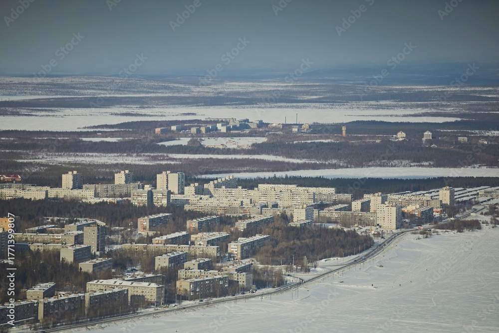 Obraz premium Urban landscape in winter against the backdrop of lakes and cloudy skies during the day. City in the Arctic