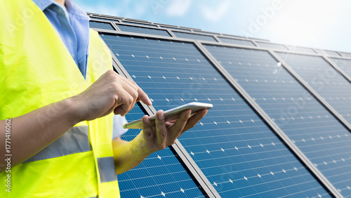 Engineer using mobile app for remote monitoring solar panels smart IoT technology