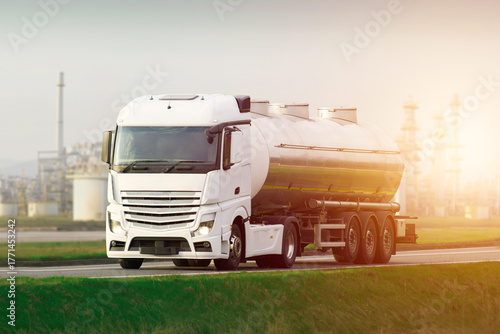 Wallpaper Mural The Journey of Energy: A Gleaming Tanker Truck and Distant Refinery Towers Torontodigital.ca