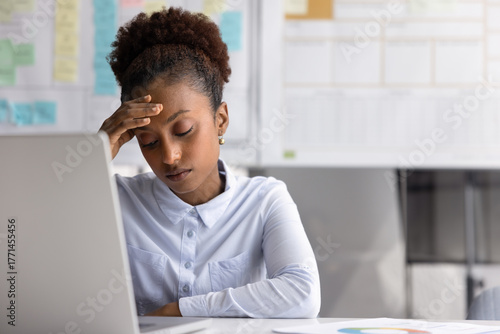 Quadro su tela Upset stressed young businesswoman sit by notebook exhausted from overwork