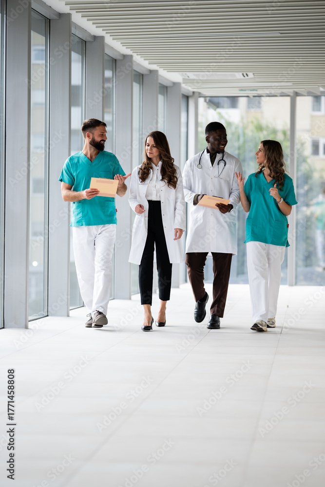 Fototapeta premium Medical team walking and discussing in hospital corridor