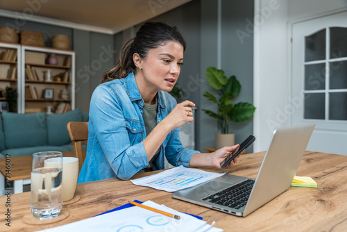 Valokuvatapetti Freelance businesswoman in home office reviewing charts and dictating a voice no