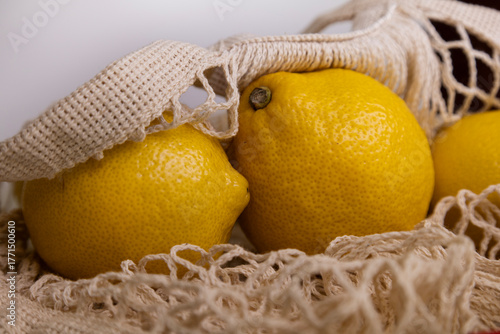 Macro Yellow Lemons in Net Bag – Minimal Flat Lay on White Background with Copy Space