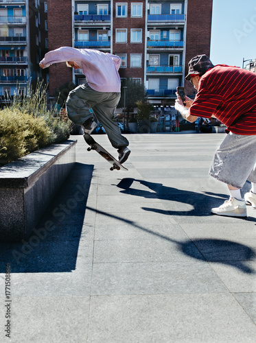 Skater Jumping Onto Ledge While Friend Records Trick