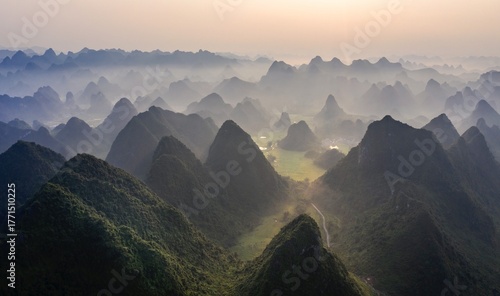 Aerial view of limestone karsts rise majestically through a soft, ethereal mist, creating a mesmerizing landscape, Cao Bang, Cao Bang, Vietnam.