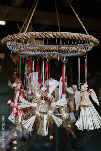 Handmade straw decorations at the craft market. Traditional decorations with red ribbons create a festive and folkloristic atmosphere.