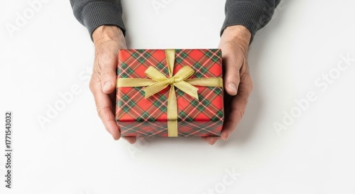 Elder Man holding a red plaid gift box on a white background. Holiday present for Christmas, birthday, New Year, or special occasion.
