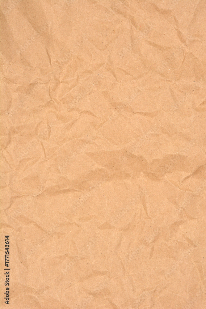 Fototapeta premium A vertical full-frame shot captures the wrinkled and crumpled texture of plain brown kraft paper, perfect for a rustic background