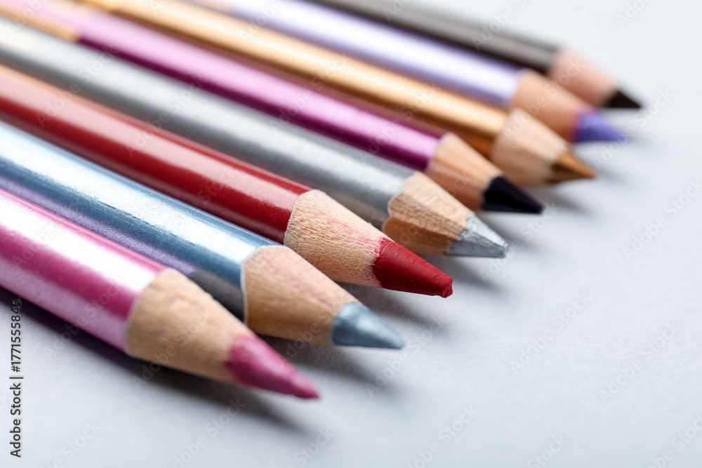 Fototapeta premium Different eye pencils on light background, closeup