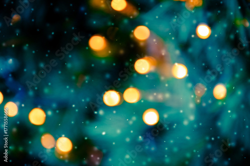 Golden bokeh lights on a dark background. Snowflakes falling down. Christmas magical light background, overlay or lens flare effect