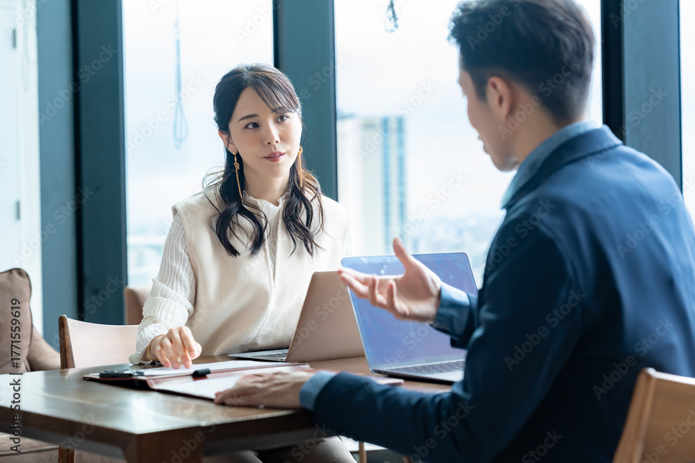 Obraz premium 男女2人のビジネスパーソンが打ち合わせや商談をしている様