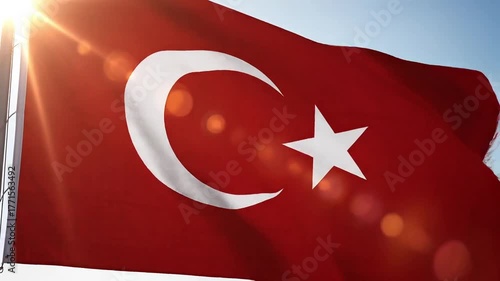 Waving Turkish flag with crescent moon and star illuminated by bright sunlight.