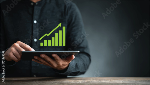 Businessman holding tablet with rising financial chart indicating positive growth