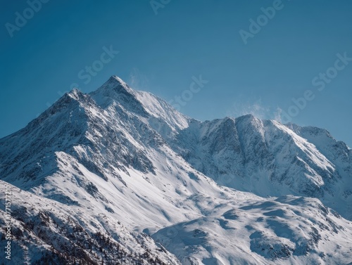 Expansive Snow-Covered Mountains under a Clear Blue Sky, showcasing rugged peaks and vast winter landscape