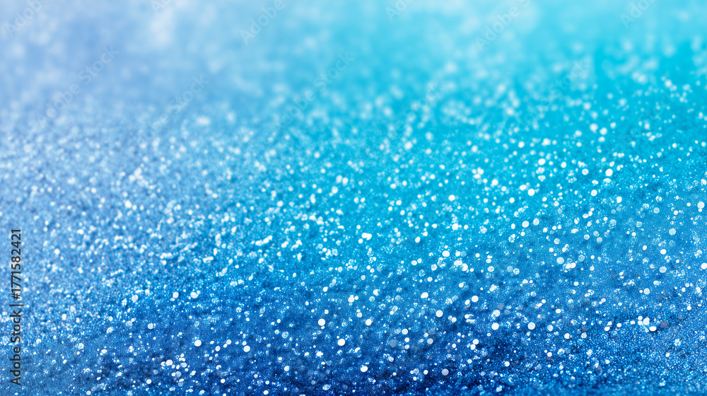 Obraz premium きらめく雪と光が舞う青いグラデーション背景