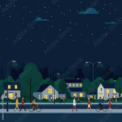 People walk and bike along the street in a residential area at night.