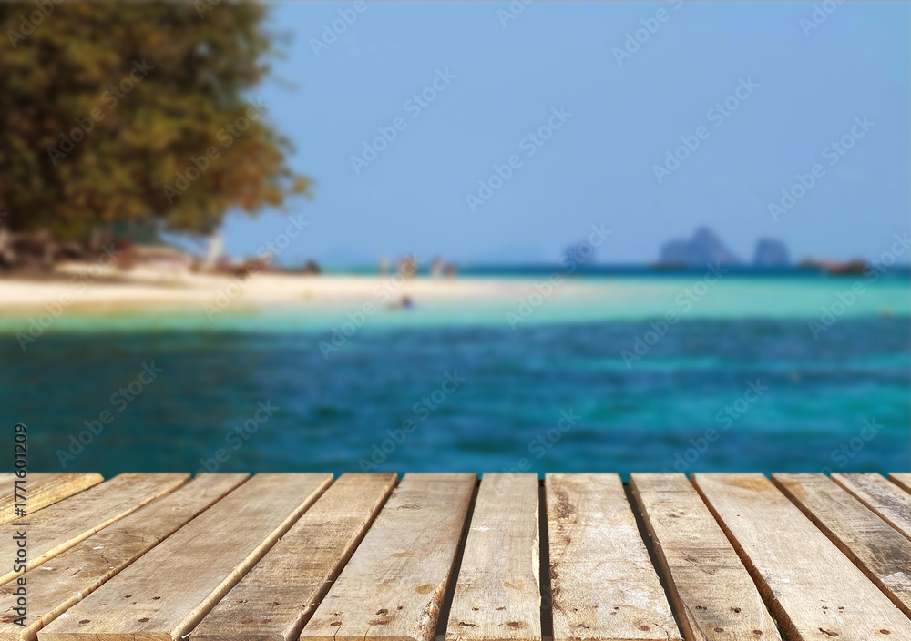 Fototapeta premium Wooden table top on the beach or sea.Party on the beach sunshine time concept.For montage product display or design key visual layout.View of copy space.
