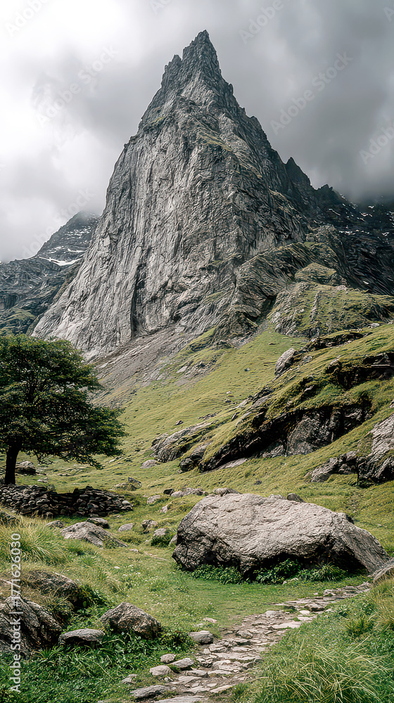 Obraz premium Rugged Stone Trail Leading to Majestic Craggy Mountain Peak Under Clouds