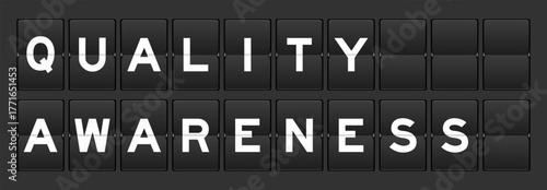 Black color analog flip board with word quality awareness on gray background