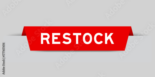 Red color inserted label with word restock on gray background
